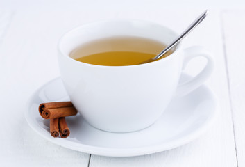 Green tea and cinnamon on wooden table.
