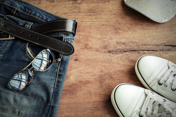 Blue jean, cap and shoes on old wood background