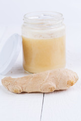 Fresh ginger with honey on wooden table.