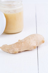 Fresh ginger with honey on wooden table.