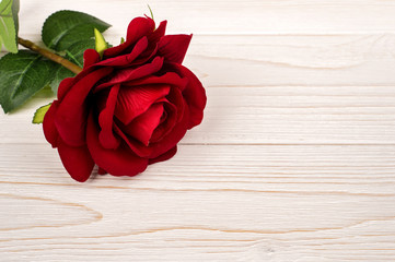 Artificial roses on the wooden background.