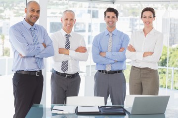 Business team smiling at camera arms crossed