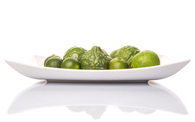 Lime, makrut or kaffir lime and calamansi on white plate