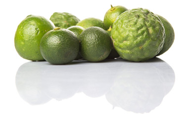 Lime, makrut or kaffir lime and calamansi over white background