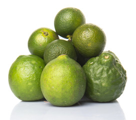 Lime, makrut or kaffir lime and calamansi over white background