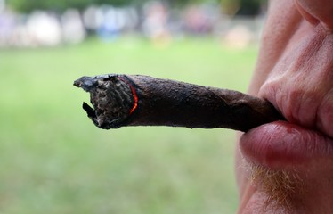 smoker with cigar in mouth and burning coals