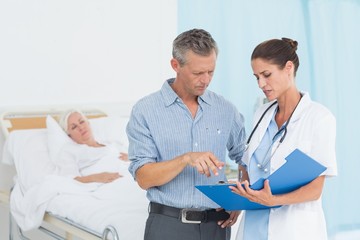 Fototapeta premium Doctor explaining report to female patient and husband