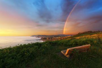 Bench near Sopelana coast with rainbow - Powered by Adobe