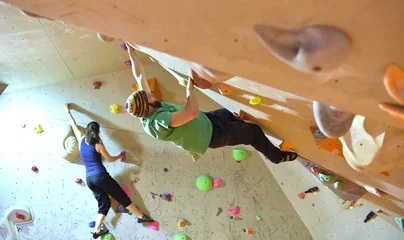 Selbstklebende Fototapete Bergsteigen Frau und Mann bouldern in einer Kletterhalle