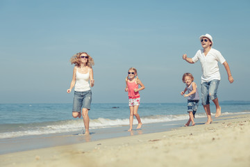 Happy family walking on the beach at the day time. Concept of fr