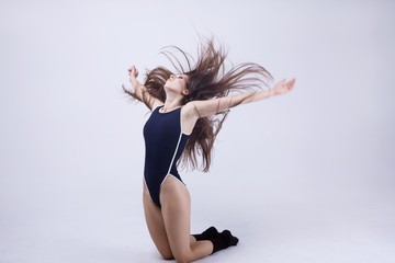 Fototapeta na wymiar young beautiful dancer posing on a studio background