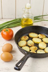 fried potatoes with fried eggs in a frying pan