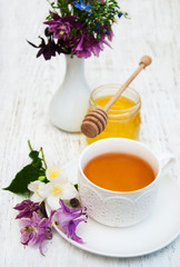 Obraz na płótnie Canvas Cup of tea, honey and flowers