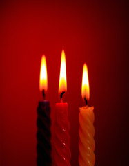 Fototapeta na wymiar Three Candles On Red