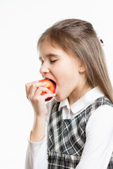 Isolated portrait of cute schoolgirl biting red apple