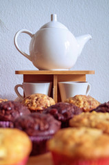 Muffins mit Kanne und Tassen 
