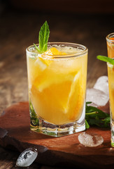 Refreshing cocktail with soda, orange, mint and ice, selective f