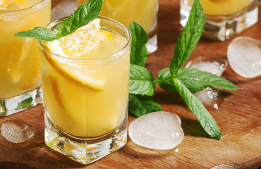 Refreshing cocktail with soda, orange, mint and ice, selective f