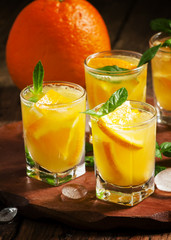 Refreshing cocktail with soda, orange, mint and ice, selective f