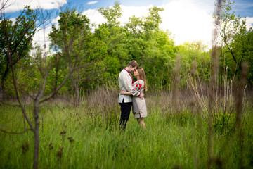 couple in traditional ukrainian clothes hugging at forest