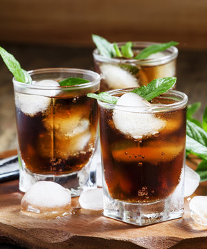 Cuba Libre with mint and ice in a glass, selective focus
