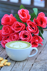 Green tea with milk and artificial flowers.