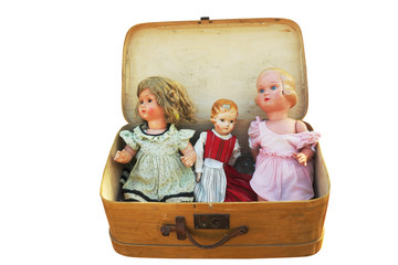 three vintage doll in an old suitcase