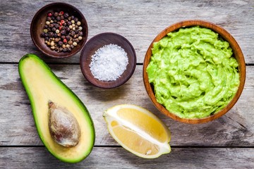 ingredients for homemade guacamole: avocado, lemon, salt and pepper
