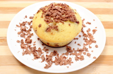 Fresh baked muffins and grated chocolate on white plate