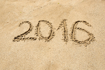2016 digits written on sand at beach