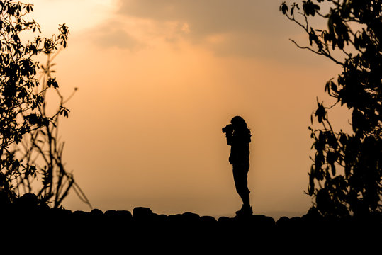 silhouette of photographer taking picture at sunset