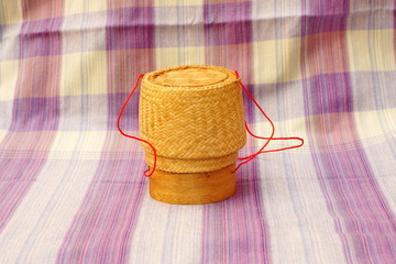 Kratip, thai bamboo sticky rice container on loincloth fabric background