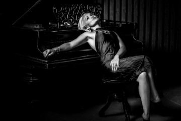 Beautiful girl sitting near piano black and white photo black and white photo