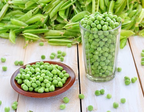 Green peas in a glass on a wooden background