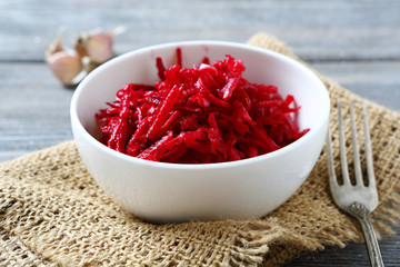 Fresh grated beet in a white bowl