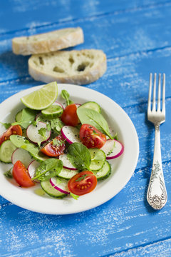 salad with cherry tomatoes, radish, cucumber and spinach 