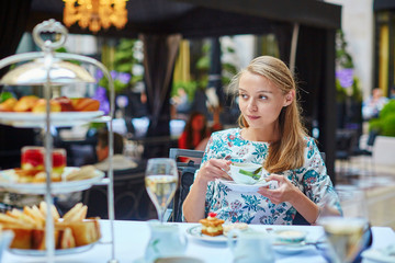 Beautiful young woman enjoying afternoon tea