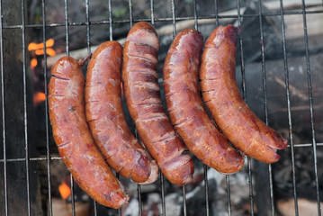 Grilling sausages on barbecue grill
