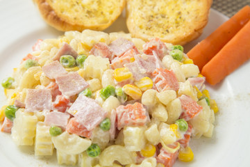 Macaroni salad with mayonnaise and vegetables.