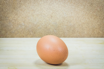 Single brown chicken egg on wood