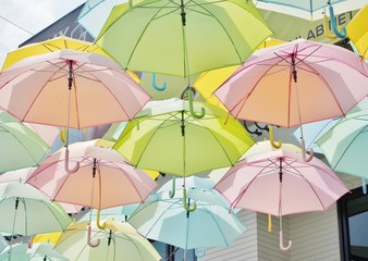 Fototapeta na wymiar A lot of multicolored umbrellas in pastel style.