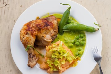Grilled chicken leg with mashed potatoes and peas