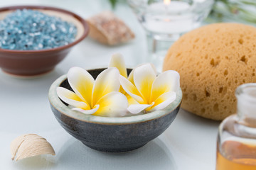 Fototapeta na wymiar Spa concept with Floating Flowers, Sponge, essential oil