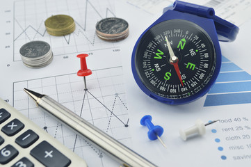 Red pin and blue compass on graph paper, target and win concept