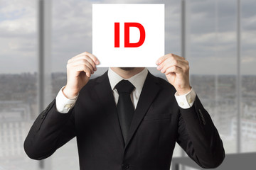 businessman hiding face behind sign id