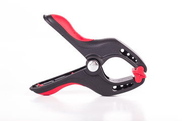 Metal spring clamp with red plastic on white background