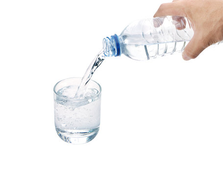 Drinking water is poured from a bottle into a glass