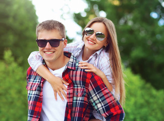 Portrait of beautiful young smiling couple in sunglasses having