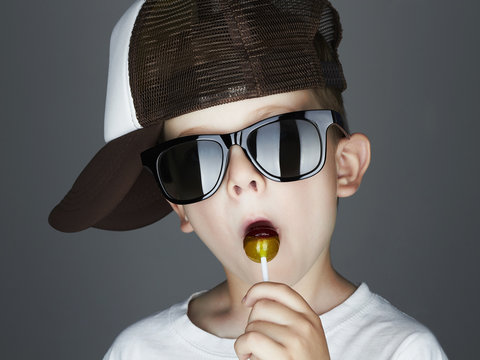 Funny Young Boy with Lollipop.Fashionable child in sunglasses