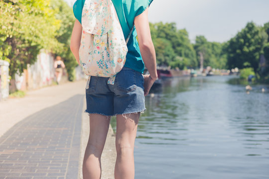 Young woman standing by canal